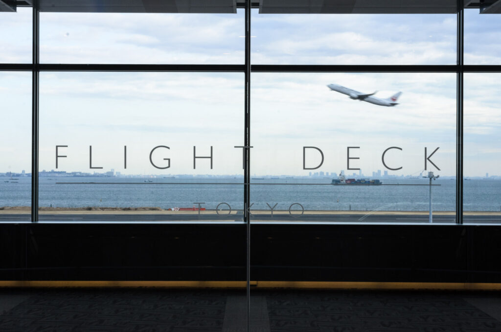 FLIGHT DECK TOKYOの文字と離陸する飛行機