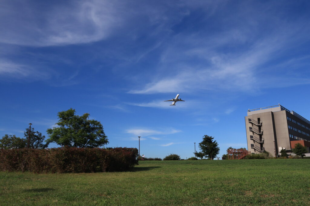B滑走路から離陸した飛行機と殿町第2公園の風景