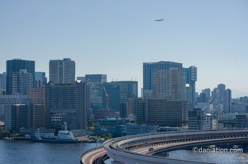 都心の景色と新ルートで着陸する飛行機の写真