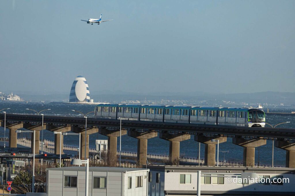 羽田空港第3ターミナル駅からモノレールとA滑走路に着陸する飛行機を撮影